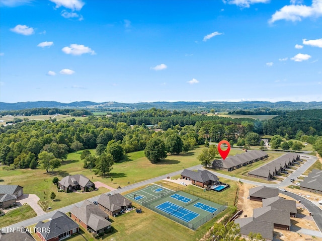 drone / aerial view featuring a wooded view and a mountain view