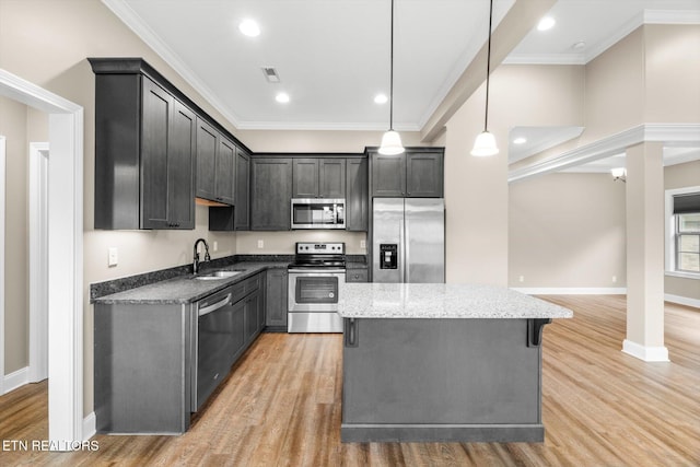 kitchen featuring light wood-style flooring, a sink, stainless steel appliances, and crown molding