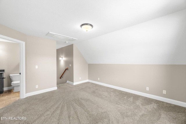 additional living space featuring light carpet, baseboards, and lofted ceiling