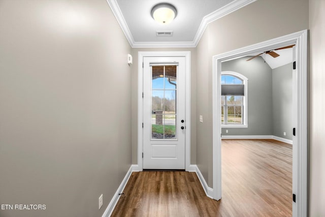 doorway to outside featuring crown molding, baseboards, visible vents, a ceiling fan, and wood finished floors