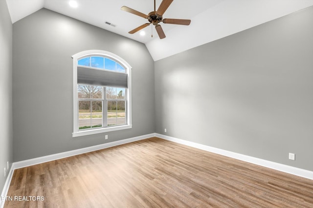 spare room featuring baseboards, visible vents, and wood finished floors