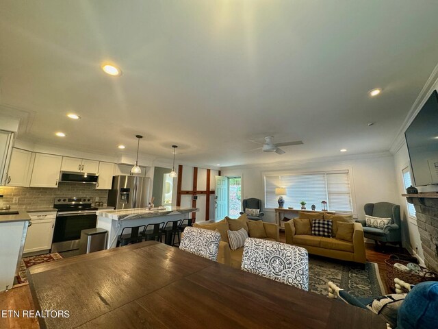 dining area featuring dark wood-type flooring, ceiling fan, and ornamental molding