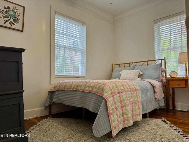 bedroom with dark wood-type flooring and ornamental molding