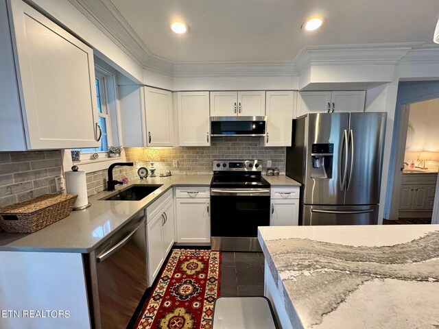 kitchen featuring sink, white cabinets, light stone counters, and stainless steel appliances