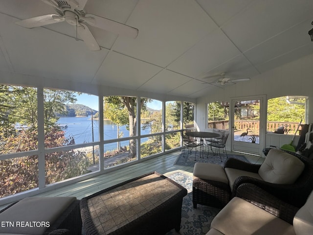 sunroom / solarium featuring a water view and ceiling fan