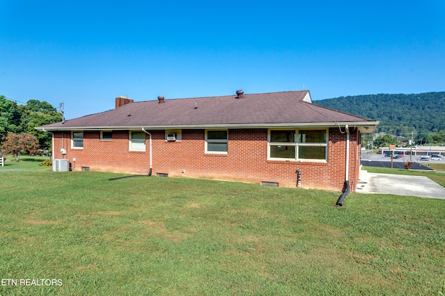 exterior space with a yard, cooling unit, a patio, and a mountain view