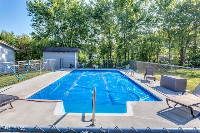 view of pool with an outbuilding and a patio