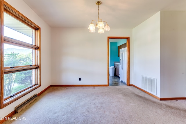 empty room with carpet flooring, baseboard heating, and a chandelier