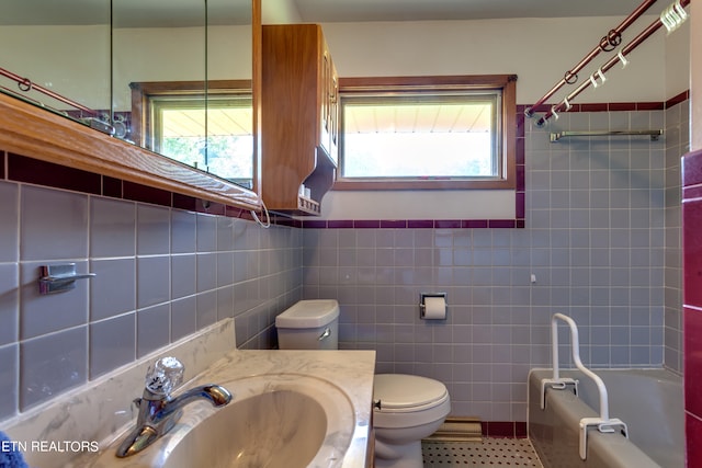 full bathroom with tile walls, toilet, bathtub / shower combination, and vanity