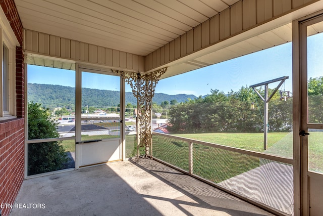 unfurnished sunroom with a healthy amount of sunlight and a mountain view