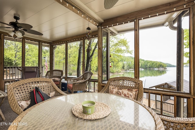 sunroom / solarium featuring outdoor dining space, a water view, and a ceiling fan