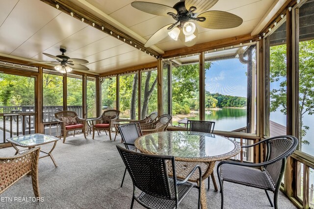 sunroom with a water view and ceiling fan