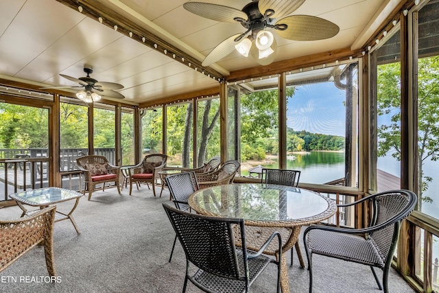 sunroom / solarium featuring outdoor dining area and a ceiling fan