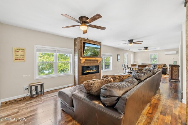 living room featuring ceiling fan, a fireplace, plenty of natural light, and hardwood / wood-style flooring