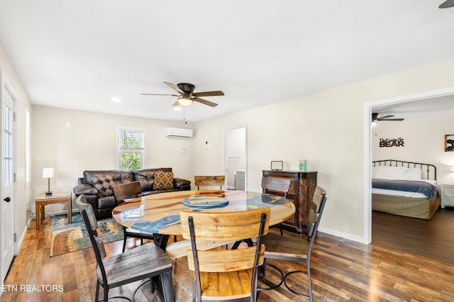 dining room with baseboards, a wall mounted AC, wood finished floors, and a ceiling fan