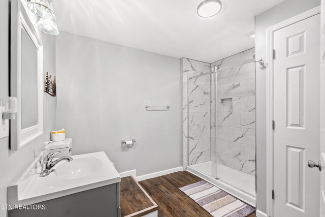 bathroom featuring vanity, wood-type flooring, and a shower with shower door