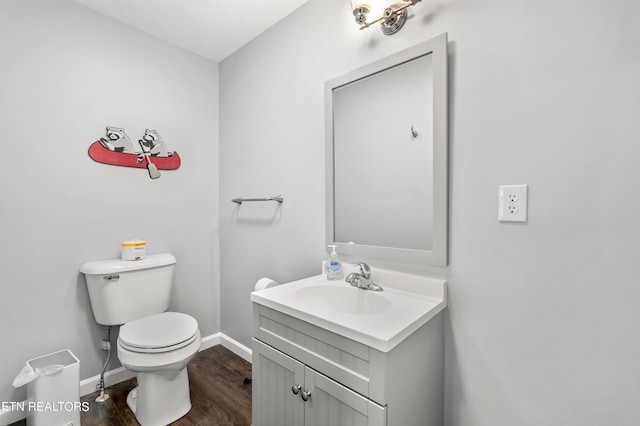 bathroom featuring baseboards, toilet, vanity, and wood finished floors