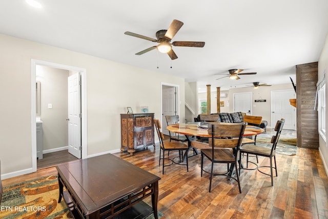 dining room with baseboards, wood finished floors, stairs, and a ceiling fan