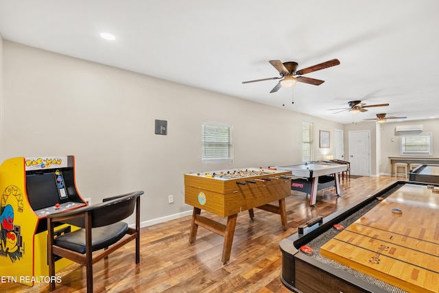 recreation room with light wood finished floors, a wall mounted air conditioner, baseboards, ceiling fan, and recessed lighting