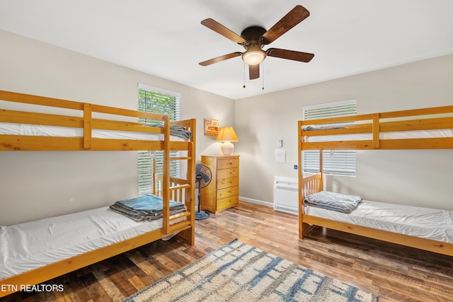 bedroom with baseboards, ceiling fan, and wood finished floors
