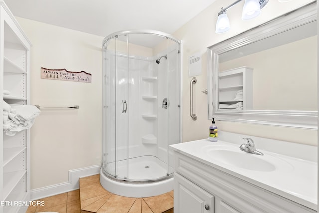 full bathroom with baseboards, a stall shower, tile patterned flooring, and vanity