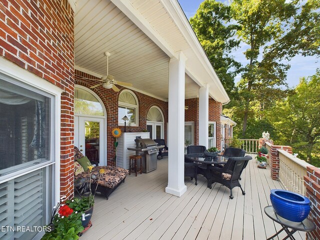 wooden terrace with ceiling fan and a grill