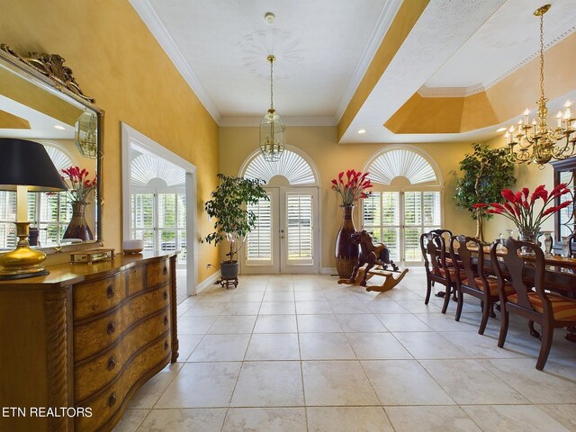 tiled dining room with a towering ceiling, crown molding, french doors, and a notable chandelier