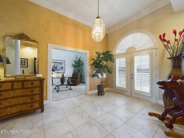 entrance foyer with light tile patterned flooring, french doors, a chandelier, and crown molding