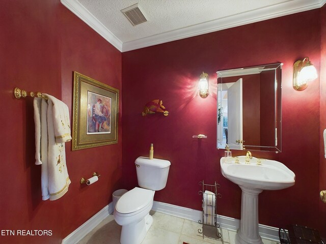 bathroom featuring toilet, ornamental molding, a textured ceiling, and tile patterned flooring