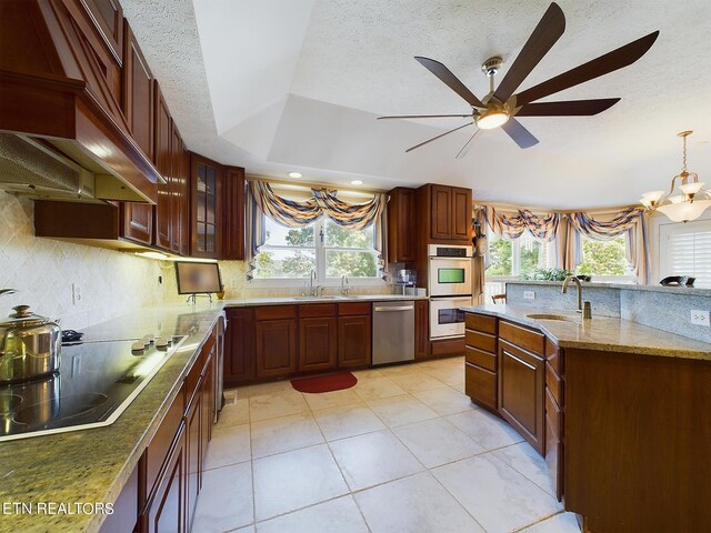 kitchen featuring stainless steel dishwasher, white double oven, stovetop, and plenty of natural light