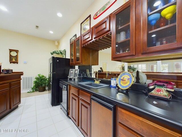 kitchen featuring black dishwasher, sink, and light tile patterned floors