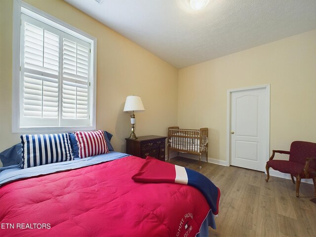 bedroom with a textured ceiling and light wood-type flooring