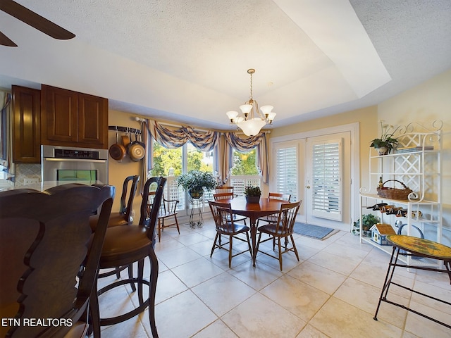 155 Lake Crest Dr, Lenoir City, TN 37772 - dining room with ceiling fan with notable chandelier, a raised ceiling, light tile patterned floors, and plenty of natural light