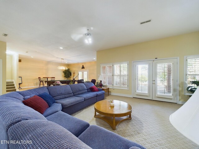 living room featuring light carpet, french doors, and ceiling fan