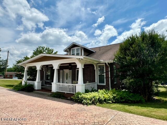 bungalow-style home with a front lawn and covered porch