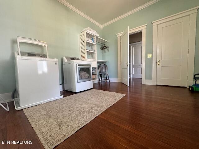 laundry room featuring washing machine and clothes dryer, crown molding, and dark hardwood / wood-style floors