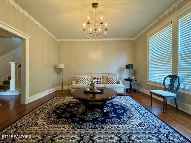 living area with an inviting chandelier, ornamental molding, and hardwood / wood-style flooring