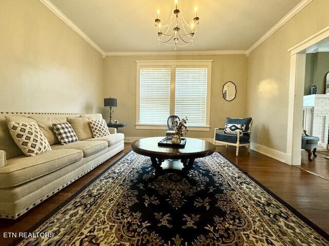 living room with crown molding, dark wood-type flooring, and a notable chandelier