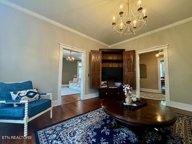 living room with crown molding, dark wood-type flooring, and a notable chandelier