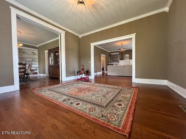 interior space featuring a chandelier, crown molding, and dark hardwood / wood-style flooring