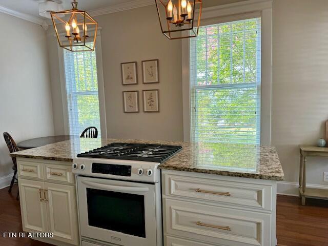 kitchen featuring light stone countertops, high end white range oven, dark wood-type flooring, decorative light fixtures, and white cabinetry