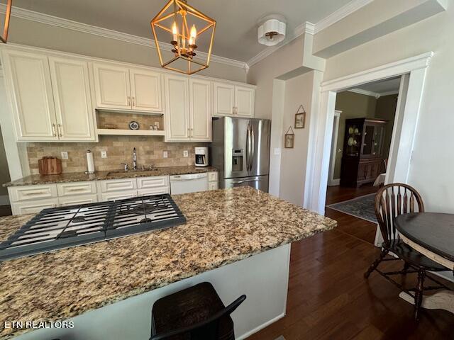 kitchen featuring pendant lighting, dark wood-type flooring, stainless steel appliances, and stone countertops