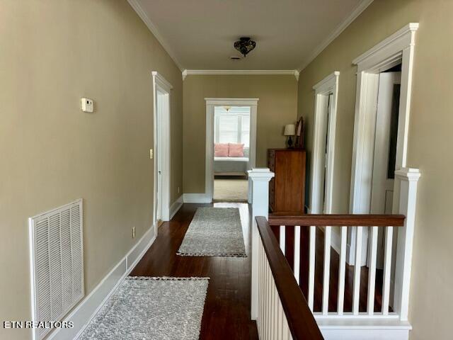 hallway featuring dark hardwood / wood-style flooring and ornamental molding