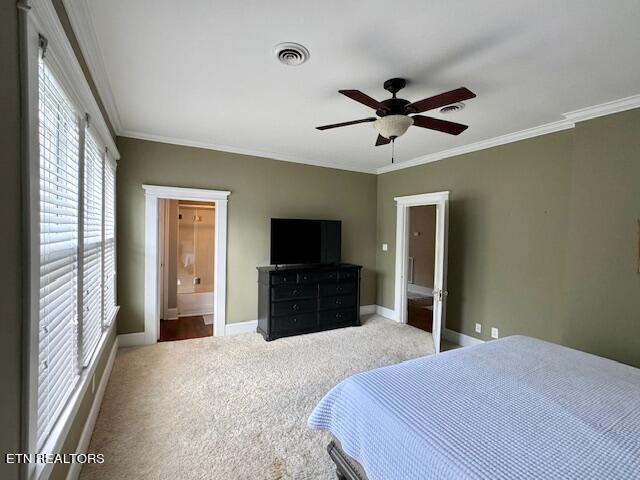 bedroom with carpet, ensuite bathroom, ceiling fan, and ornamental molding