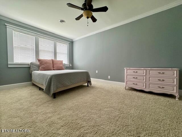 carpeted bedroom with ceiling fan and ornamental molding