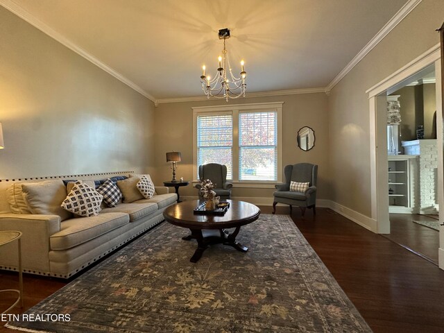 living room with dark hardwood / wood-style floors, a brick fireplace, ornamental molding, and a notable chandelier