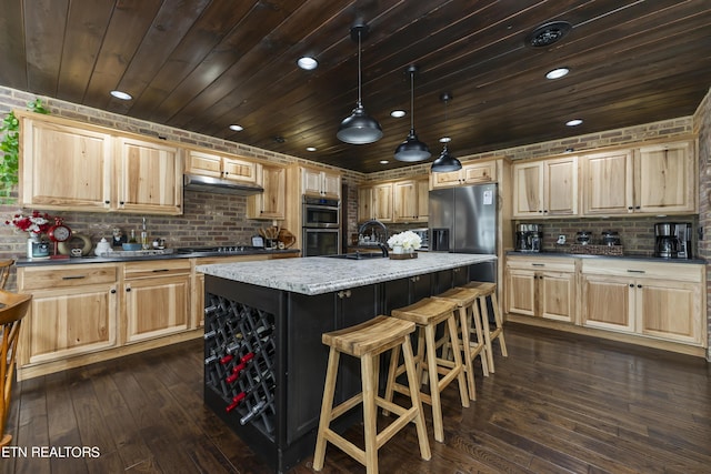 kitchen featuring sink, gas stovetop, dark hardwood / wood-style flooring, an island with sink, and pendant lighting