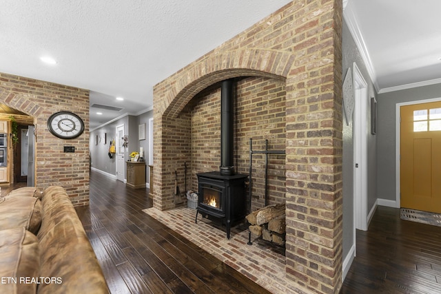 living room with dark hardwood / wood-style floors, a wood stove, and ornamental molding