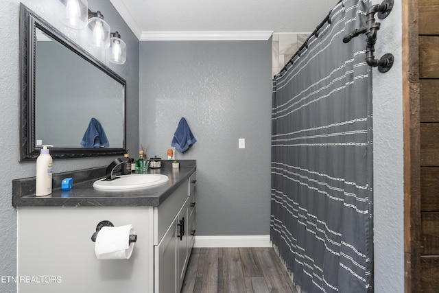 bathroom featuring vanity, hardwood / wood-style flooring, walk in shower, and ornamental molding