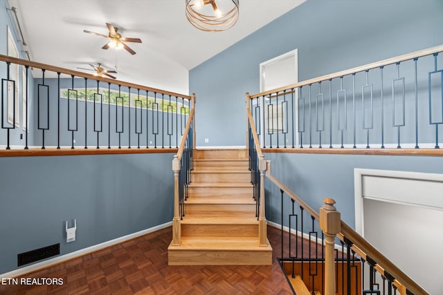 stairway with ceiling fan and parquet flooring